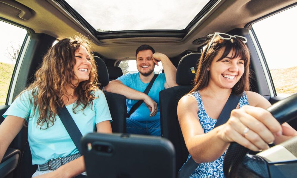 Friends driving in a car having fun on a roadtrip together